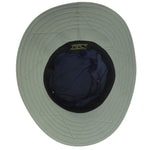 Underside of a navy blue boonie hat with grayish green colored trim with black drawstrings and breathable metal holes towards the crown