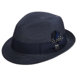 Navy blue colored fedora hat with thick darker navy blue band with blue, white, and black feather tucked in and a black and silver Stacy Adams pin below it