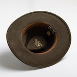 Olive colored hat with a visible brand label on a white background