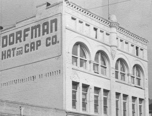 Old photo of a very tall Dorfman Hat and Cap Co. building in black and white